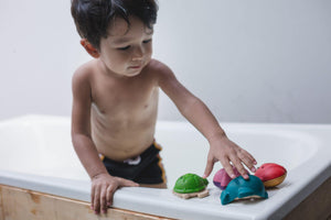 criança a brincar com conjunto de brinquedos de banho em forma de Animais marinhos da PlanToys
