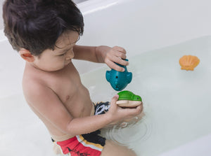 criança a brincar com conjunto de brinquedos de banho da PlanToys