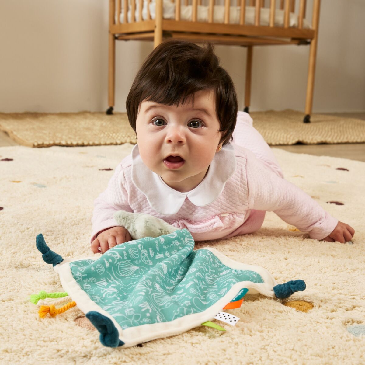 bebé a brincar com o Doudou Estrela da miniland para 0-12 meses