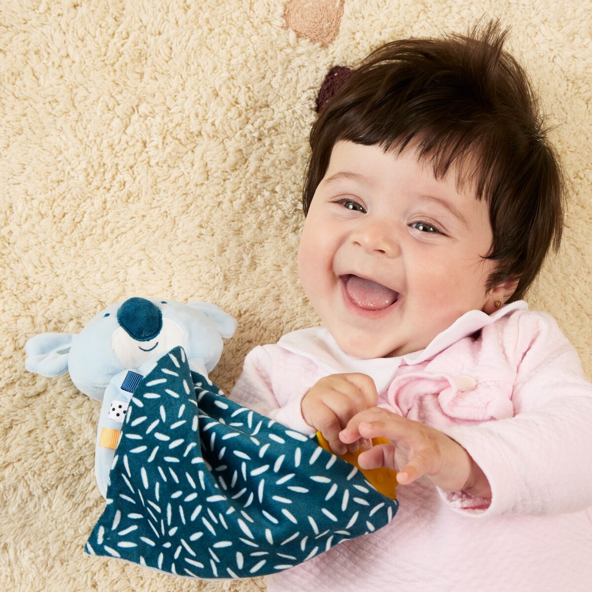 Bebé com o doudou do kit de presente com tema Coala da Miniland