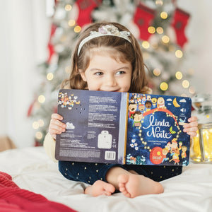 menina a ler e ouvir o livro musical com canções de Natal "linda noite"