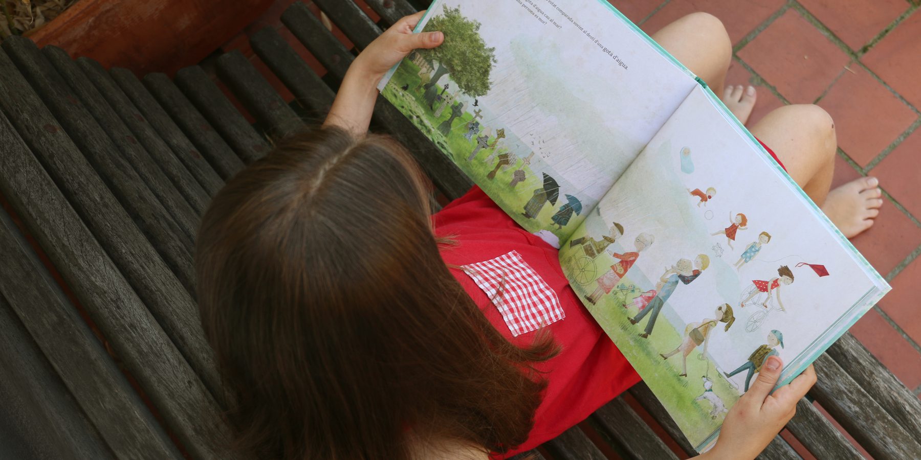 menina a ler o livro infantil  "A gota de água"