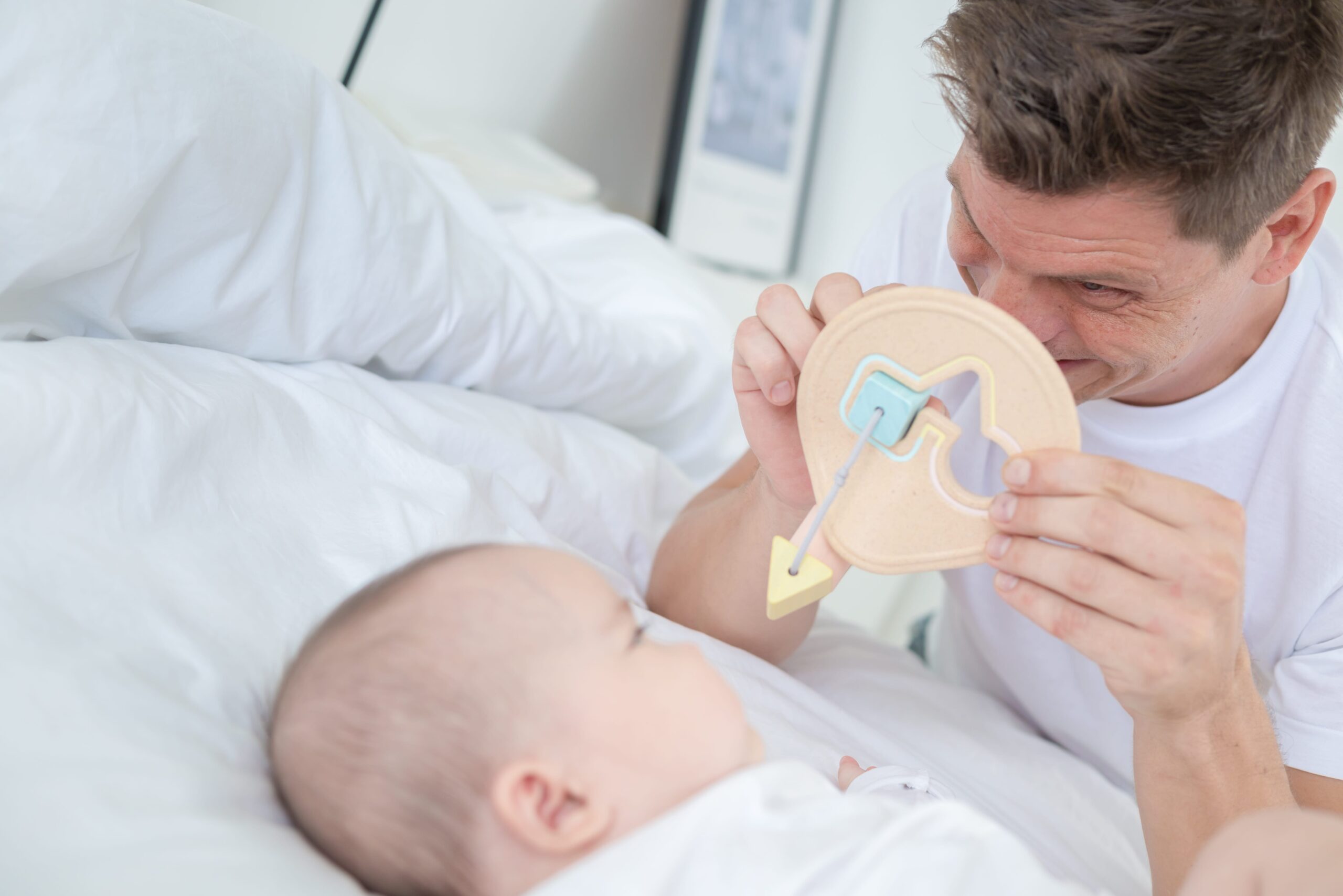 pai a brincar com bebé com brinquedo de Encaixar Formas da PlanToys