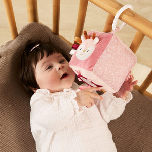 Bebé a brincar com Brinquedo Sensorial pendurado no berço